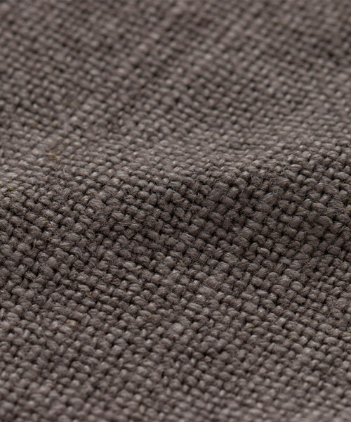 Close-up of the Fabric Swatch Ash Linen, highlighting its gray, textured weave and visible fibers with a slightly uneven surface.