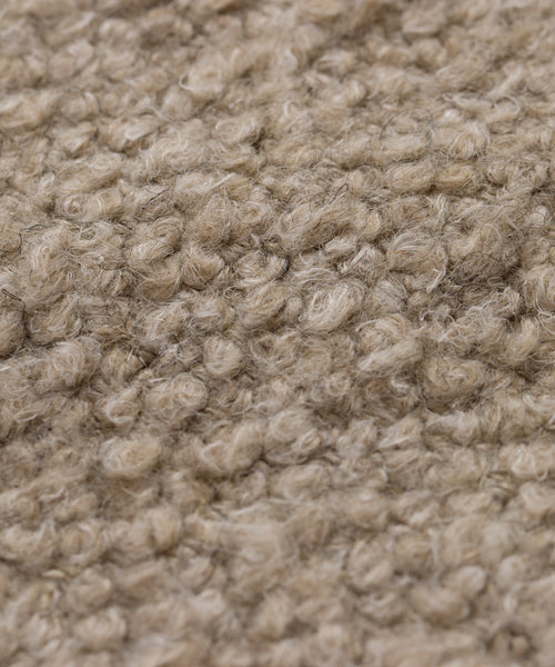 Close-up of Fabric Swatch Natural Wool Boucle, showcasing tightly packed, curly beige fibers in a loop-pile texture, similar to the cozy and soft finish seen on Jenni Kayne Furniture.
