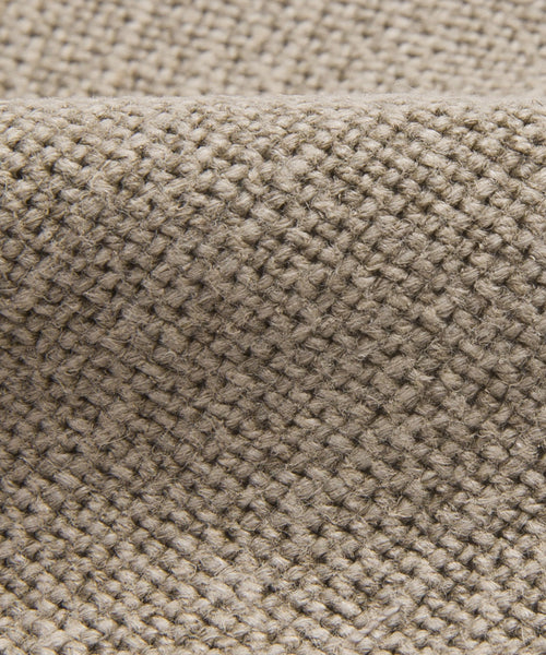Close-up of Fabric Swatch Taupe Linen, featuring a textured crisscross weave. Slight folds create gentle shadows, highlighting its detailed fibers—ideal for refined dining chair upholstery.