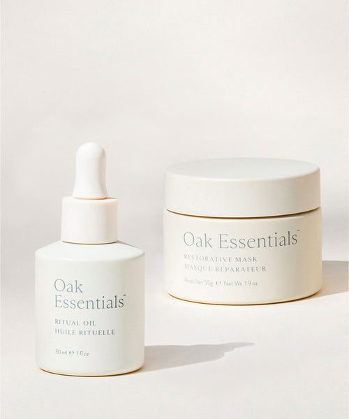 The Reset Duo—featuring two white Oak Essentials containers, a Ritual Oil dropper bottle and a Restorative Mask jar—is displayed against a soft, neutral background, making it an ideal choice for any elevated skincare routine.