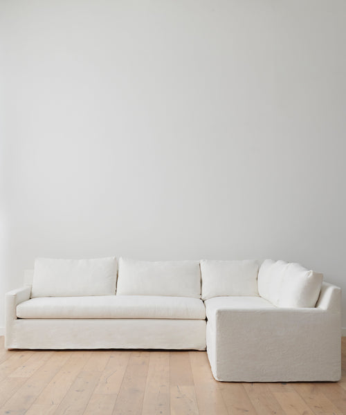 The Harbor Sectional, upholstered in plush Belgian flax linen, brings timeless elegance to any room with its refined white design.