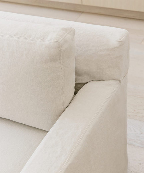 Close-up view of the Fabric Swatch Natural Linen, highlighting its soft texture and neutral beige tone, perfect for upholstery. Light wood flooring and cabinetry create a serene setting inspired by Jenni Kayne furnishings.