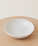 The Pacific Serving Bowl is displayed on a light wooden surface, viewed from above at a slight angle with a neutral background.
