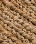 Close-up of thick, natural brown jute rope fibers woven tightly together, showing the coarse texture and braided pattern—ideal for a Rug Swatch.