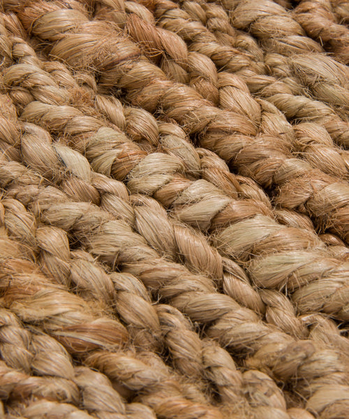 Close-up of thick, natural brown jute rope fibers woven tightly together, showing the coarse texture and braided pattern—ideal for a Rug Swatch.