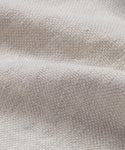 Close-up of Fabric Swatch Natural Linen featuring textured, light beige fabric with a bumpy woven surface and gentle folds that create soft shadows.