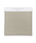 The Fabric Swatch Stone Linen is a square, light stone-gray sample with a visible woven texture and stitched edges, mounted on a white card labeled jenni kayne home and Stone Linen—ideal for the Pacific Bed.