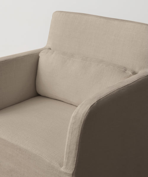 A close-up view of the Sunset Dining Arm Chair in beige linen, featuring a matching rectangular seat cushion, set against a plain white background.