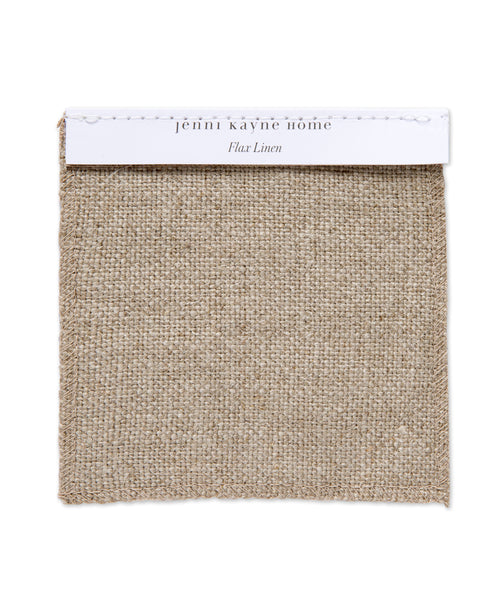 A square Fabric Swatch Flax Linen is attached to a white card labeled jenni kayne home and Flax Linen. This beige, coarse woven fabric is a popular choice for pieces such as the Miramar Sofa.