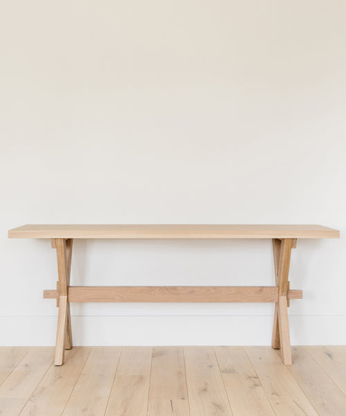 The Oak Entry Table stands against a white wall on a light wood floor, showcasing clean lines and minimalist design inspired by Jenni Kayne furniture. Its uncluttered surface enhances the simple, modern look.