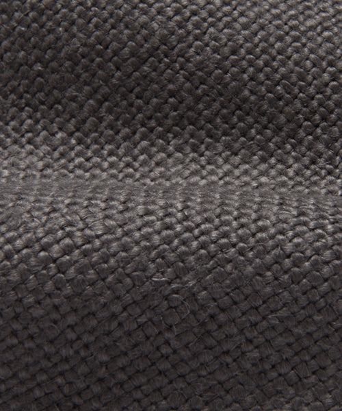 Close-up of a textured, dark gray woven fabric with visible fibers and a slightly raised, ridged surface pattern, similar to the quality found in the Miramar Chaise Slipcover.