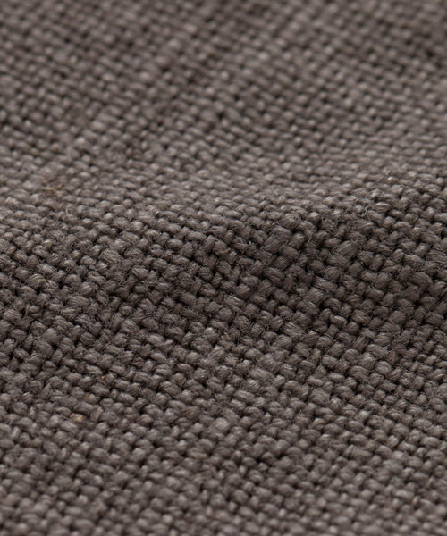 Close-up of a textured, brown woven fabric with visible fibers and a grid-like weave pattern, similar to the natural look of the Sunset Dining Chair Slipcover.