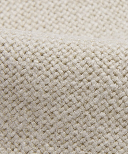 Close-up of the Sunset Dining Arm Chair Slipcover in thick sandstone linen, featuring a beige woven fabric with a textured crisscross pattern that showcases sturdy threads and a natural fiber feel.