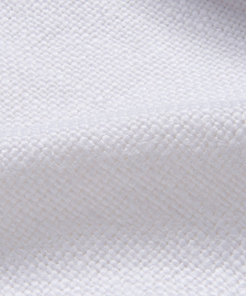 Close-up of the Miramar Sofa Slipcover, featuring white linen textured fabric with a woven diamond pattern and gentle folds. Its soft, slightly raised surface highlights an intricate weave—perfect for adding elegance to any sofa.