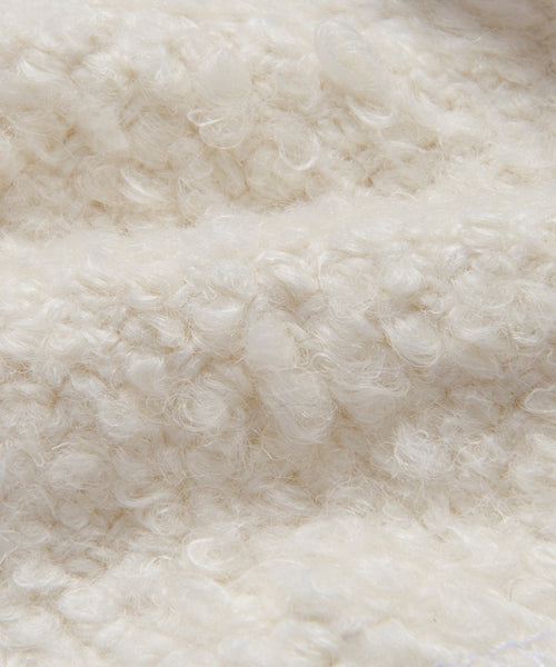 Close-up of the Fabric Swatch Ivory Wool Boucle, featuring a curly, looped surface in soft ivory. Its wool-like texture adds a cozy, inviting look—ideal for stylish upholstery projects.